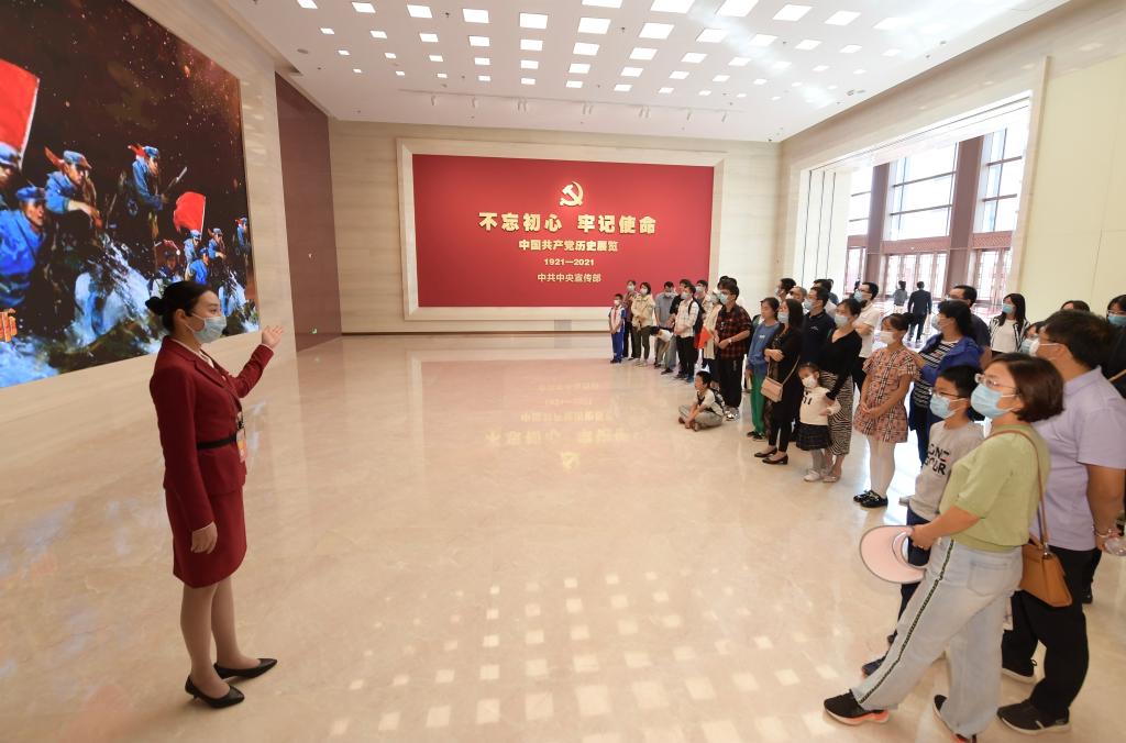 參觀者在中國共產黨曆史展覽館展廳聆聽工作人員講解（2021年10月1日攝）。新華社記者 李賀 攝